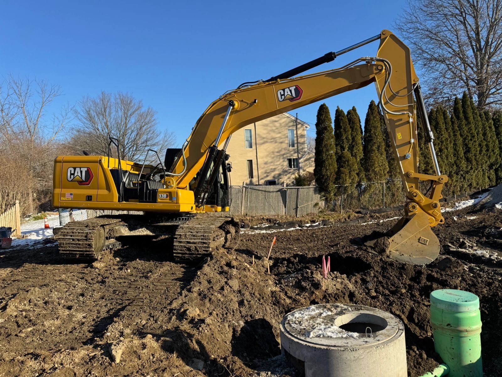 CAT excavator beside a newly set concrete drainage structure